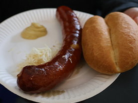 Eine Portion Käsekrainer mit Semmel, Kren und Senf.